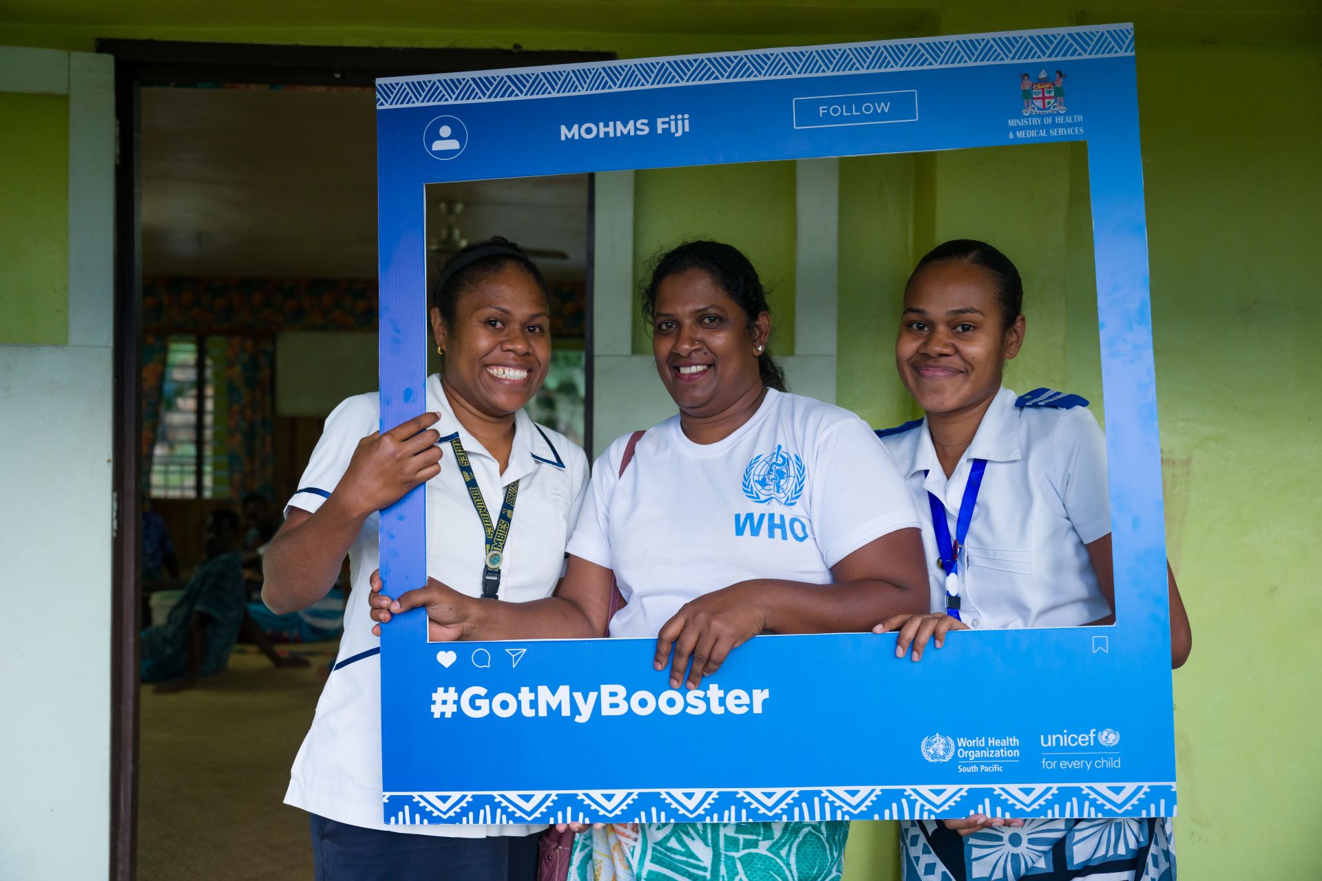 Nurses pose with a twitter photo frame promoting COVID-19 vaccination